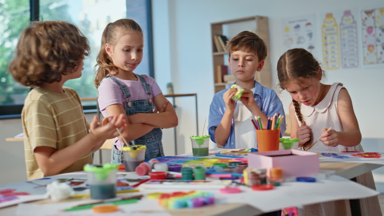 Children working art workshop using colorful materials on school desk closeup