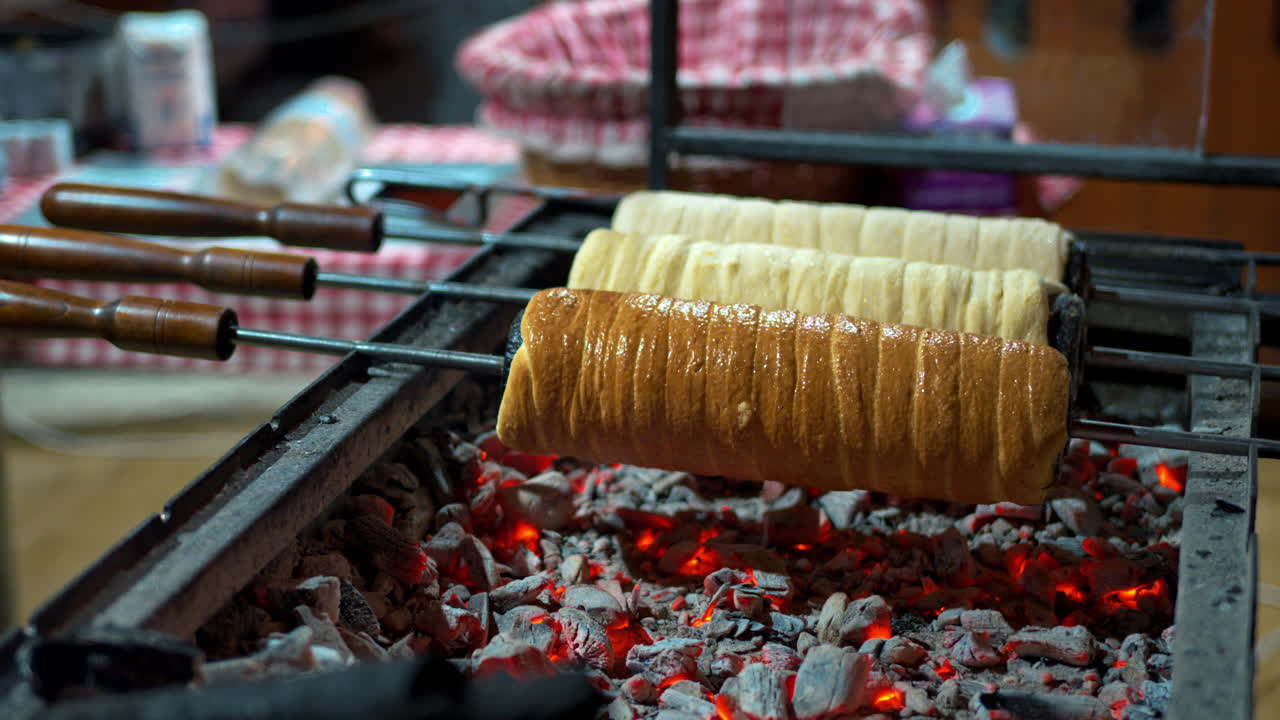 Close up of chimney cakes spinning on smoldering coal