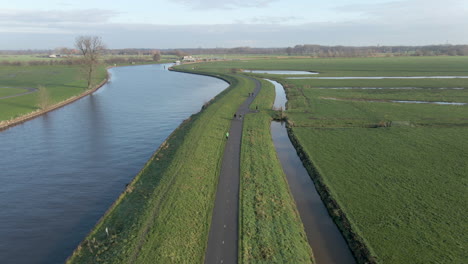 aerial of cyclists and joggers moving over dike in the netherlands