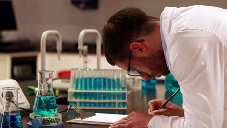 Scientist-taking-notes-on-his-experiment