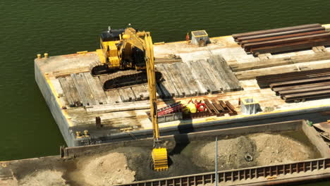 Heavy-machinery-on-a-barge,-constructing-on-the-polluted-Mississippi-River