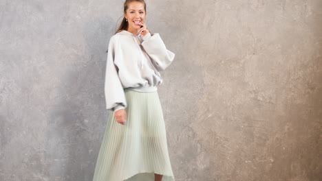 woman in fashionable outfit posing in front of a concrete wall