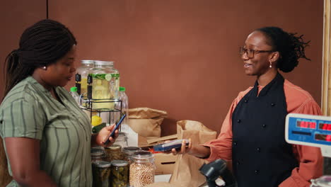 shopper paying with smartphone at pos terminal