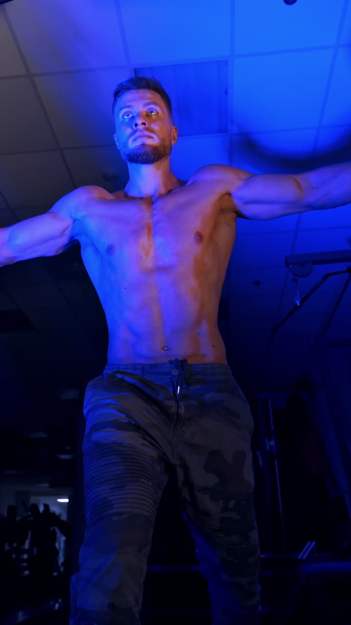 Exercise for triceps in the gym. Training of muscular man in the gym. Vertical video