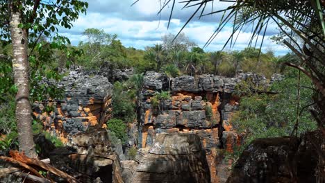 tiro inclinado hacia abajo mirando hacia un agujero en el suelo creado a partir de la cueva lapa doce con una jungla dentro y coloridos acantilados en el parque nacional chapada diamantina en bahia, noreste de brasil
