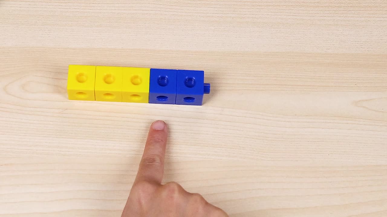 Hand organizing cubes on a wooden surface