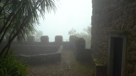 defensive guard tower wall of moors castle with very thick fog and mist