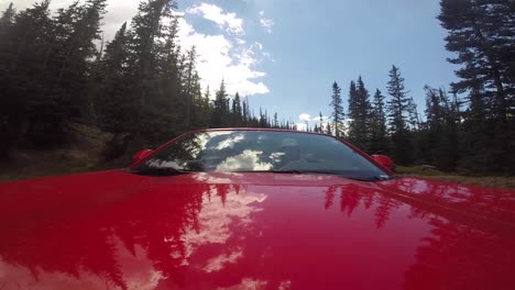 red car with two men driving through rocky mountain national park