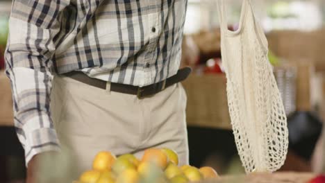 sección media de un hombre afroamericano de alto nivel comprando en una tienda de alimentos saludables, cámara lenta