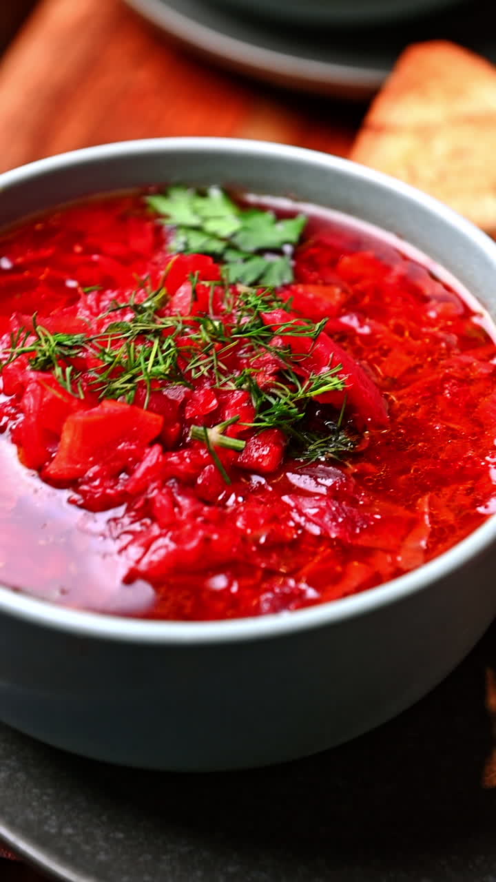 Traditional Ukrainian borscht with dill and parsley. Bright red beet soup served hot with herbs and rich broth