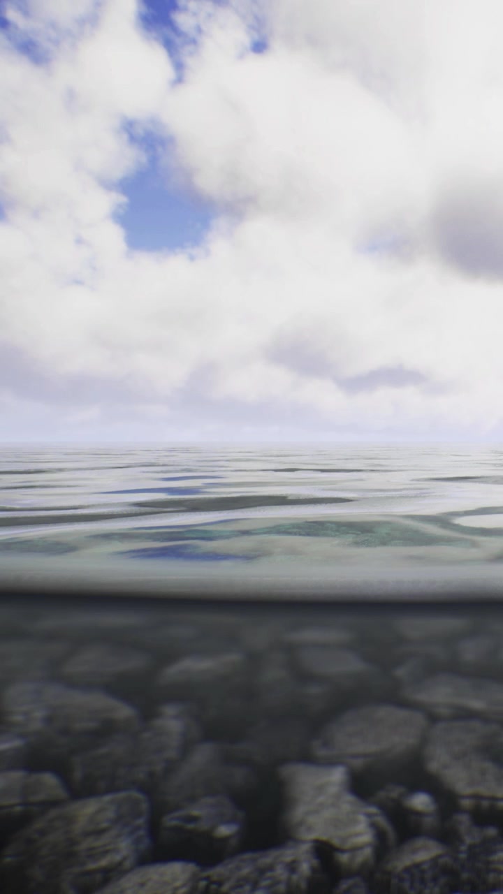 Waves gently lap against smooth pebbles under a vast cloudy sky