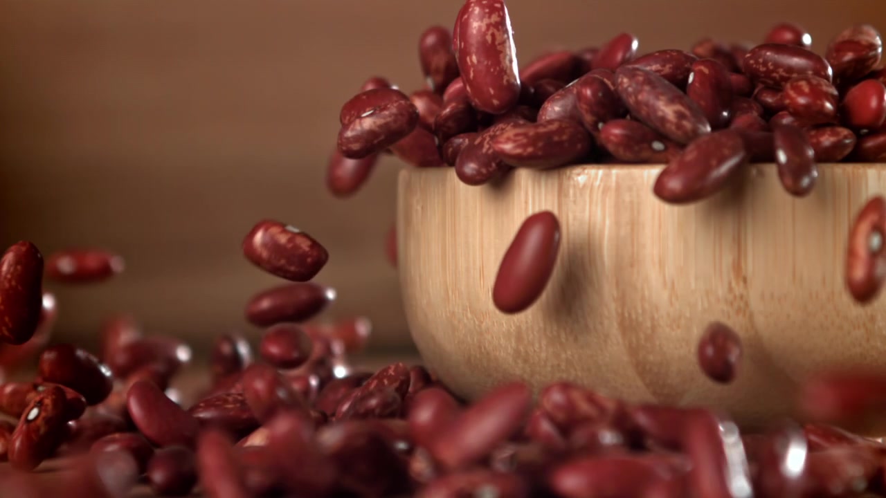 Red Kidney Beans Falling into a Wooden Bowl in Slow Motion