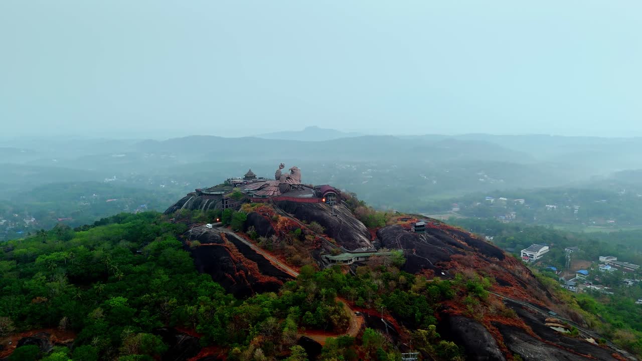 Luftbilder av Jatayu Para i Kerala, India, med verdens største fugleskulptur plassert på toppen av en steinete ås. Videoen fremhever dramatiske fjellformasjoner, panoramautsikt.