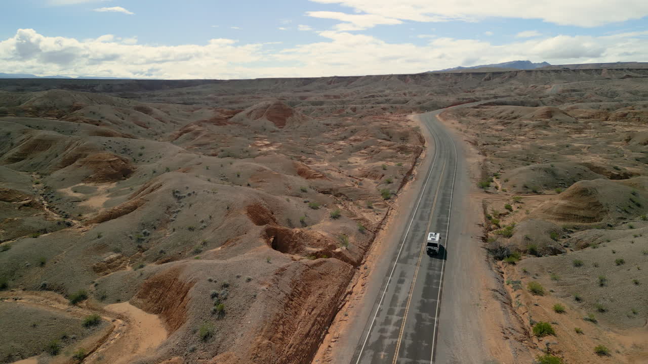 panorámica alrededor de una caravana que conduce a lo largo de un camino tranquilo en el desierto