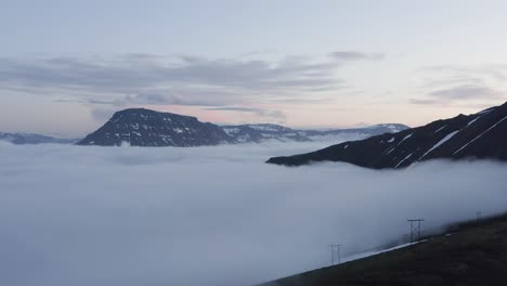 panoramic view of reyðarfjörður fjord covered in thick low clouds, aerial