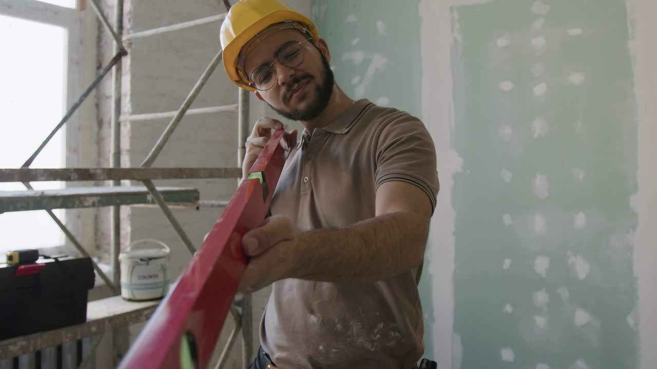 Construction worker using a level