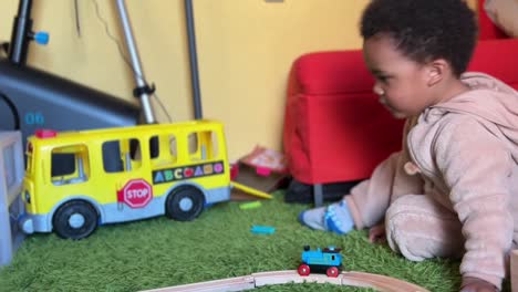 Niño-Afroeuropeo-De-Dos-Años-Jugando-Con-Un-Tren-De-Juguete-En-Casa