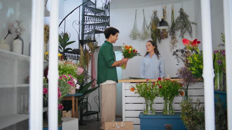 floristry professional sell flowers in plant store. african man shopping bouquet