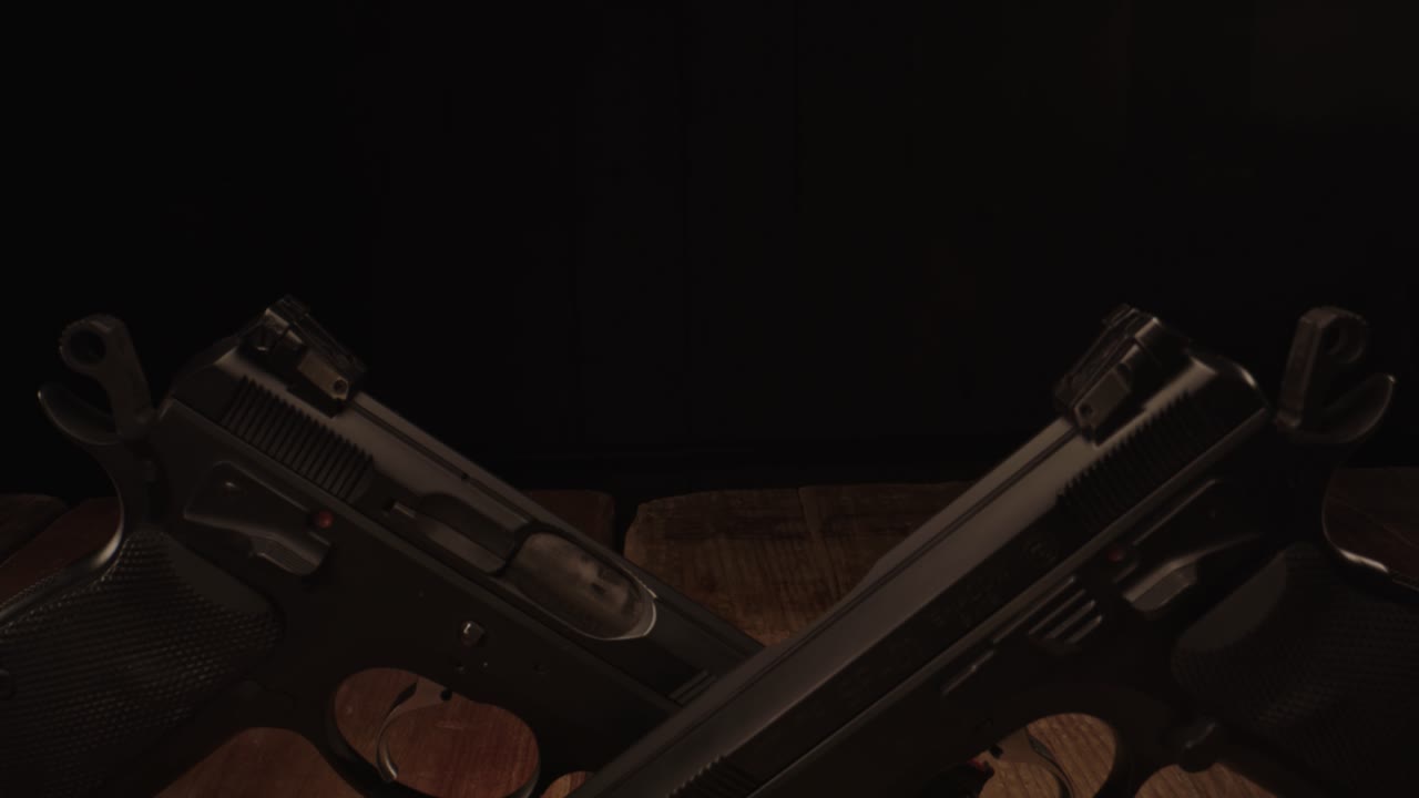 dolly revela dos pistolas amartilladas sobre una mesa de madera