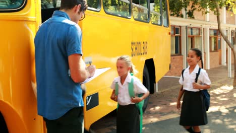maestro tomando asistencia mientras el estudiante entra en el autobús