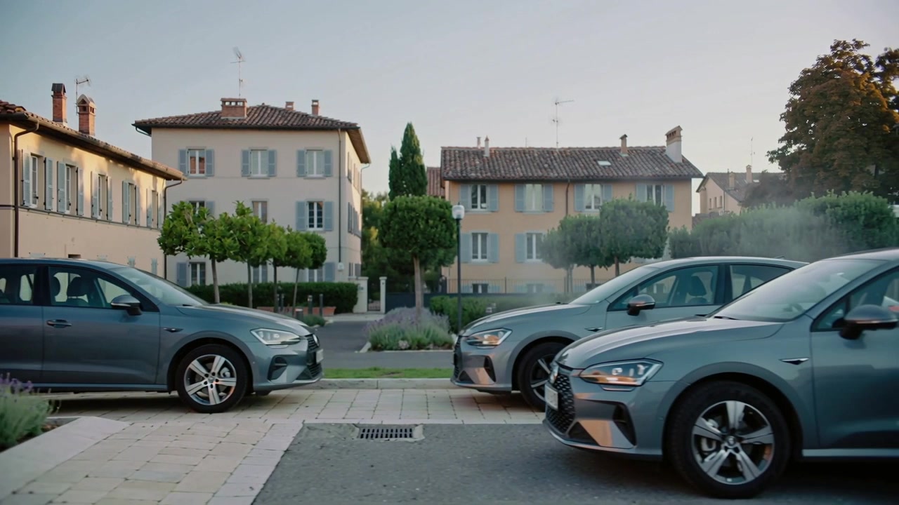 Tre auto grigie in movimento che avanzano su una strada tranquilla, l'auto a destra che entra, aprendo la strada