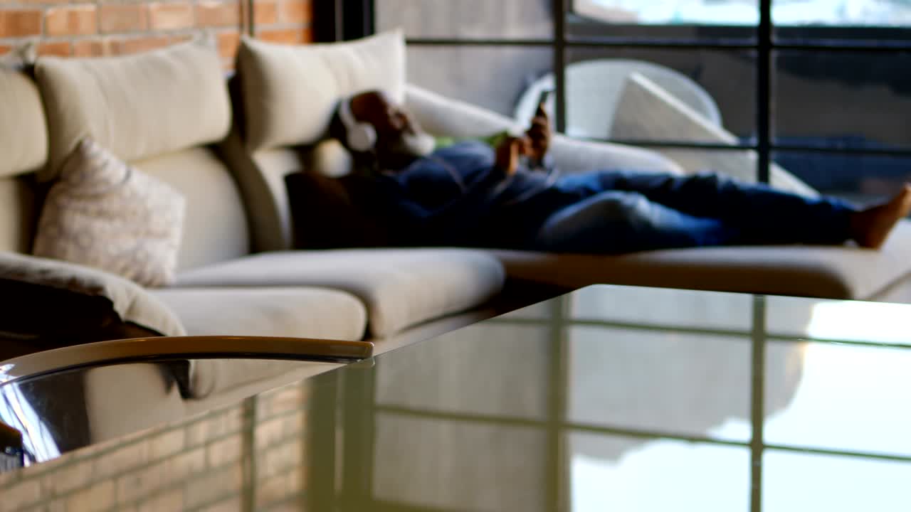 hombre mayor escuchando música en el teléfono móvil en la sala de estar 4k