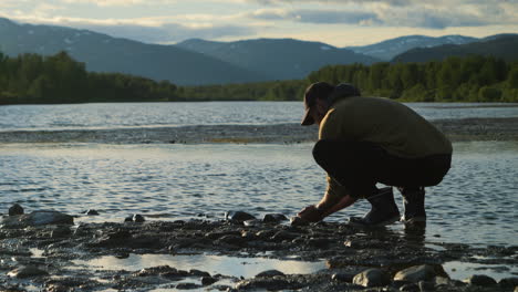 Hiker-drinks-water-straight-from-river-and-enjoys-view,-Hemavan,-Sweden