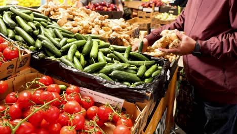 man selecting vegetables at market stall