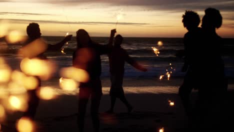 amigos jugando con chispas en la playa 4k