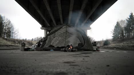 a solitary tent under an overpass, surrounded by smoke and remnants of life, illustrating resilience and survival in challenging urban environments
