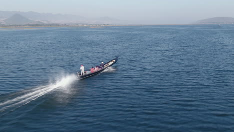 traditional long boat saling on full speed over moebyel lake in myanmar