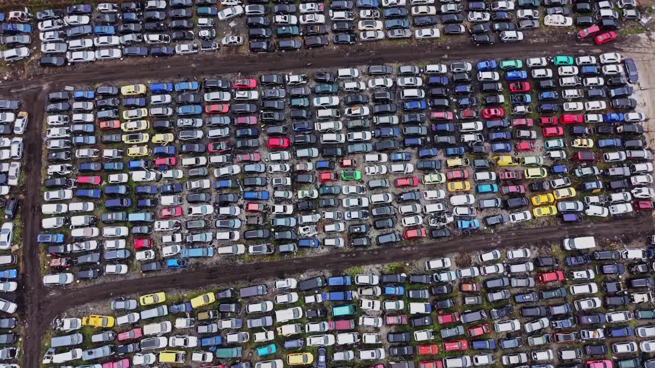 Aparcamiento lleno de coches en filas organizadas y colores aleatorios