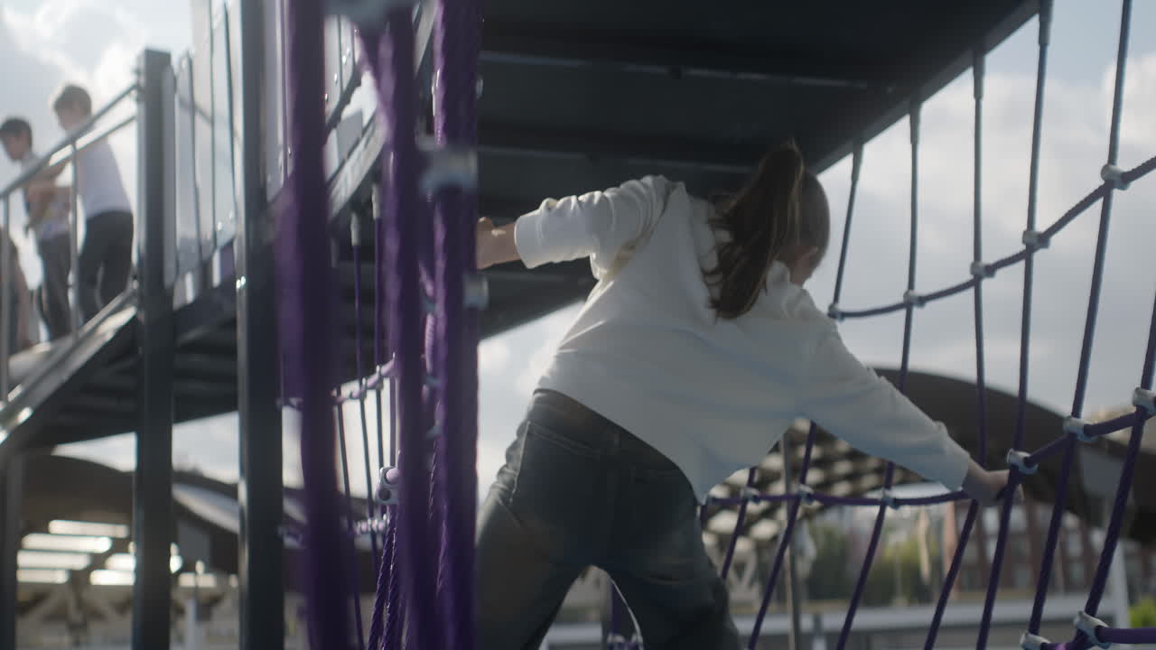 niño trepando en equipos de parque infantil