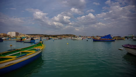 Beautiful-and-picturesque-timelapse-of-some-fishing-boats-stranded-in-the-sea-off-the-coast-of-Marsaxlokk,-Malta