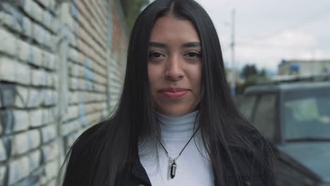 Close-up-of-a-young-hispanic-woman-walking-while-facing-the-camera