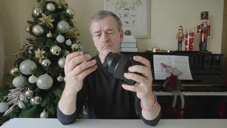 a man inspects a camera lens ready to clean it