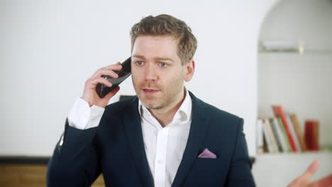 handsome young businessman is shouting instructions on his phone