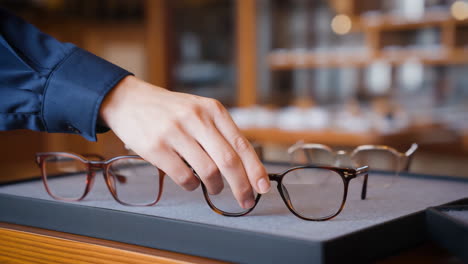 person choosing eyeglasses in an optical shop