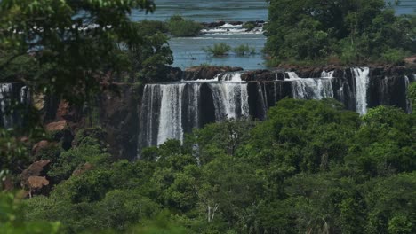 amazing picturesque rainforest landscape hiding colourful waterfalls in jungle, beautiful trees and green scenery with large group of huge waterfalls hidden in iguazu, brazil