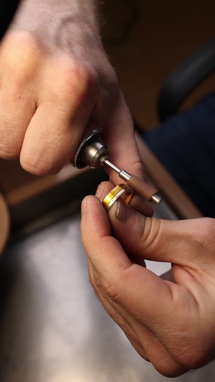 Close-Up of Jeweler's Hands Polishing a Gold Ring with a Rotary Tool
