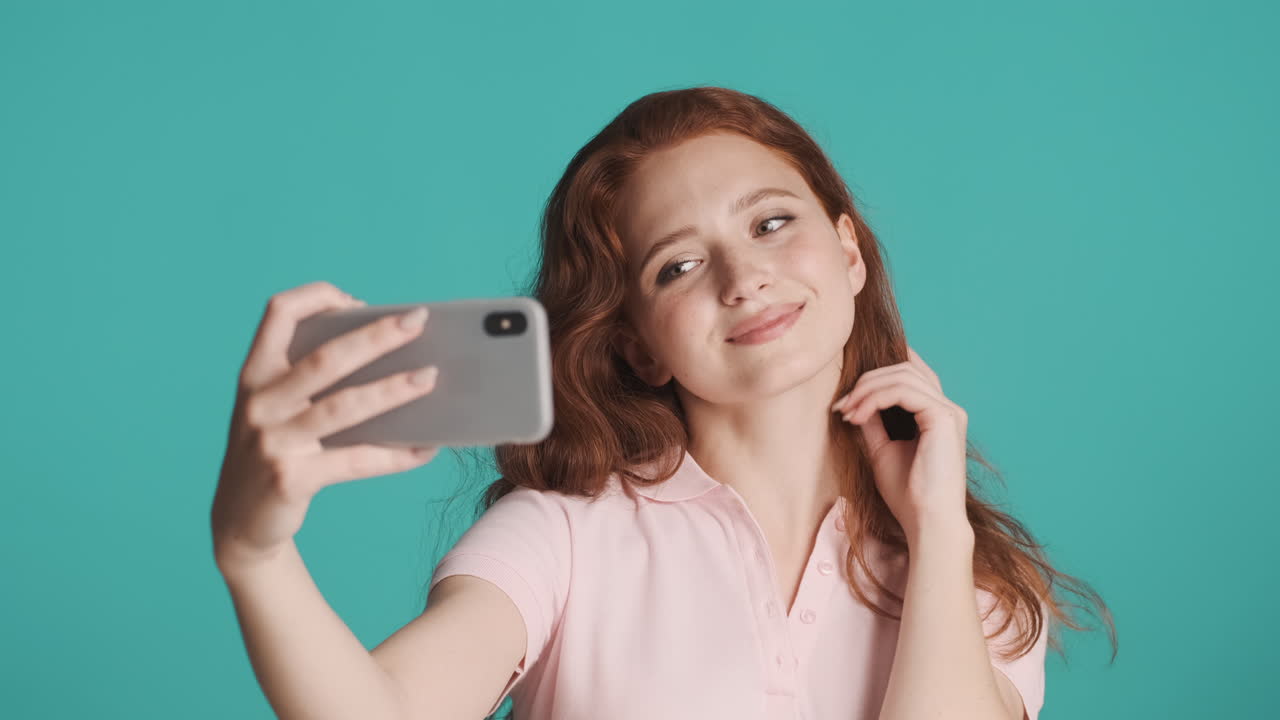 은 머리의 소녀가 카메라 앞에서 색 바탕에.