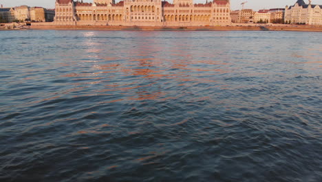 aerial view to hungarian parliament from the danube river at sunset, budapest, hungary