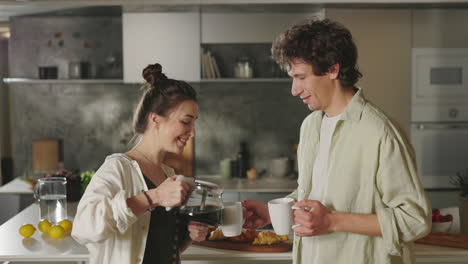 couple pouring coffee in kitchen