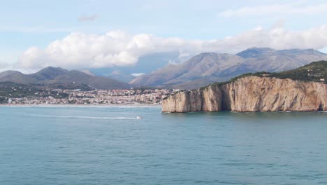 Magníficas-Vistas-Panorámicas-Del-Promontorio-Montagna-Spaccata,-Lancha-Motora-En-Aguas-Marinas,-Ciudad-Costera-De-Gaeta-Y-Montaña-En-El-Fondo,-Italia,-Círculo-Aéreo