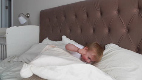 parents having fun with their little daughter on bed. family spending time at the morning