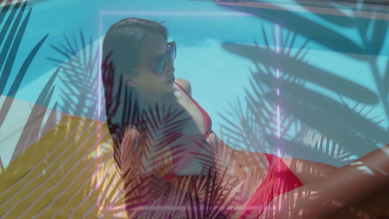 Woman reclining on towel by turquoise pool wearing sunglasses showing technology charts over water