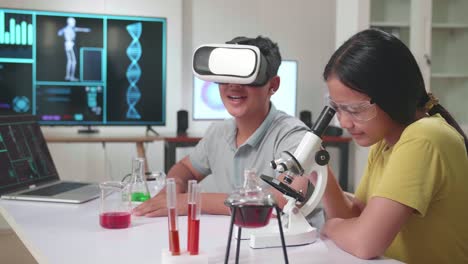 young asian boy and girl learning science experiment in laboratory at classroom. study with vr headset and a microscope