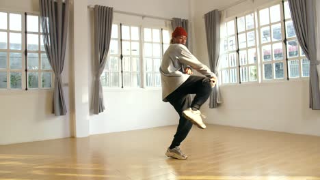 young male breakdancer training in studio, slow motion