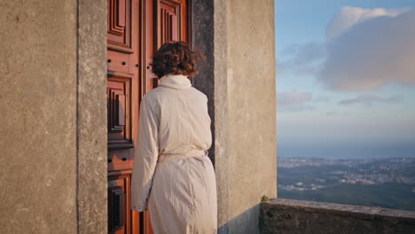 tourist looking wooden door medieval building at windy weekend. woman explorer