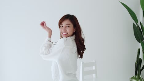 lovely asian woman happy dancing with glad emotion and smiling in the white room